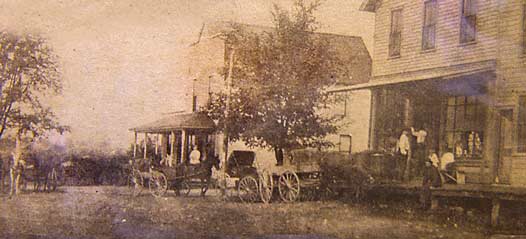 Looking west on Burlington just east of Main. The building on the left was Brigg's Butcher Shop. The building on the right was Grumhaus Grocery. From around 1895.